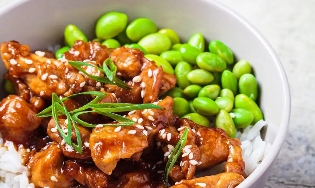 Teriyaki chicken bowl with rice, edamame, sesame seeds, scallions