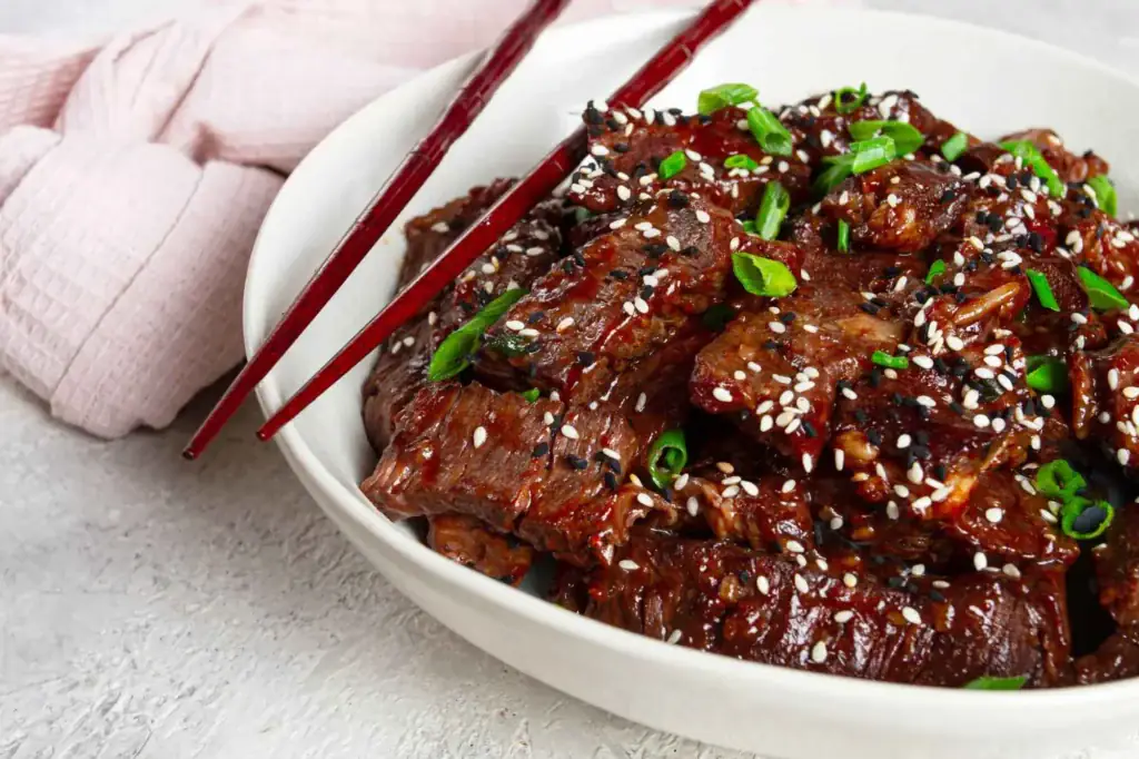 Sakura of Japan teriyaki beef takeout in bowl, sesame and scallions
