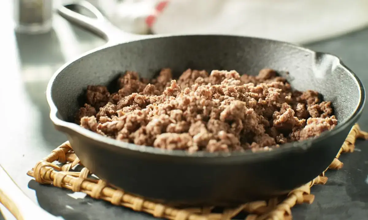 Teriyaki ground beef cooked in a cast-iron skillet