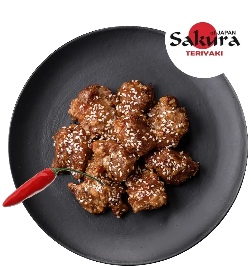 Sakura Teriyaki sesame chicken bites on black plate with red chili