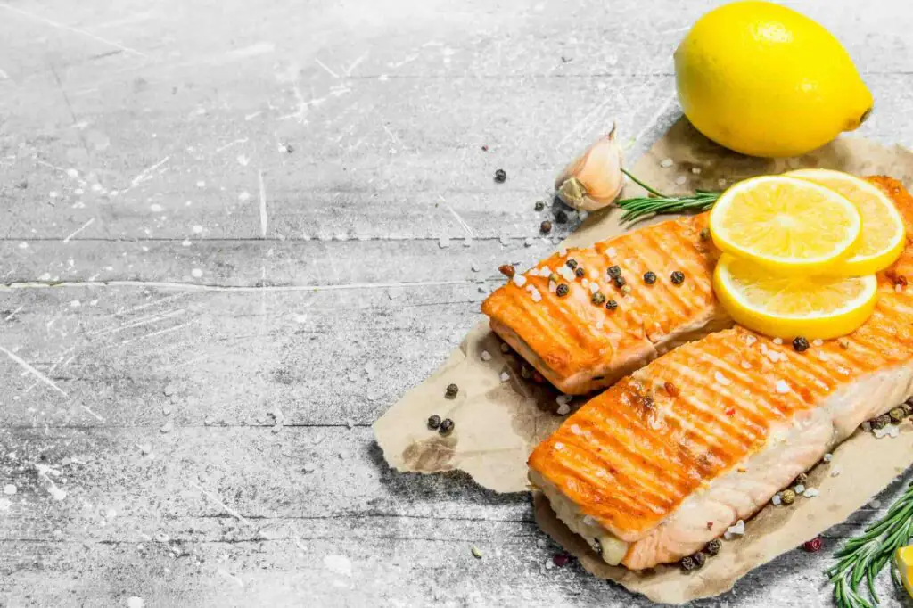 Grilled salmon fillets with lemon slices, peppercorns and rosemary
