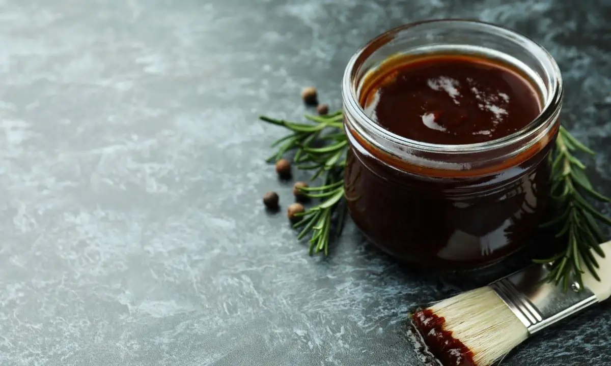 Jar of teriyaki glaze with basting brush and rosemary sprigs