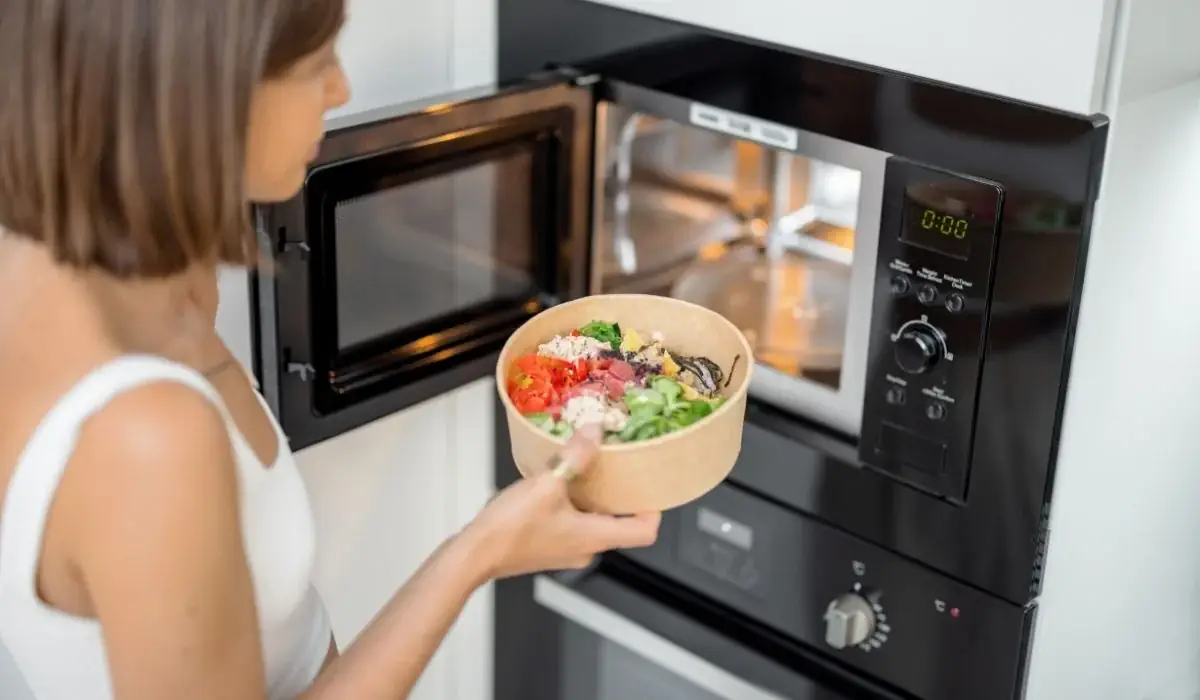 Placing Sakura of Japan Teriyaki takeout bowl into microwave to reheat