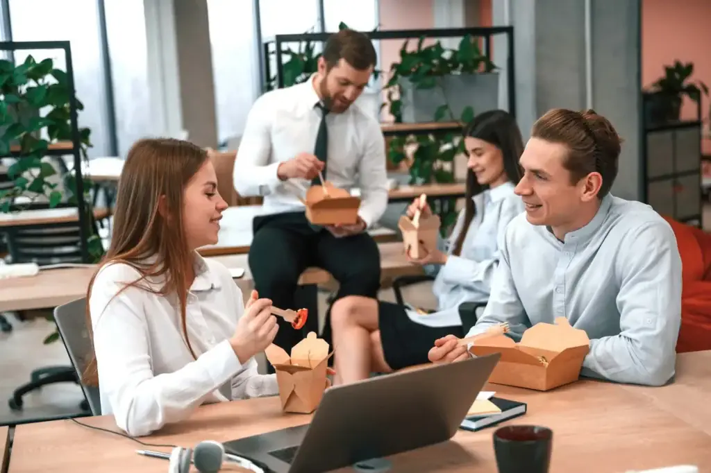 Office coworkers enjoying Sakura of Japan teriyaki takeout in an office lunch setting